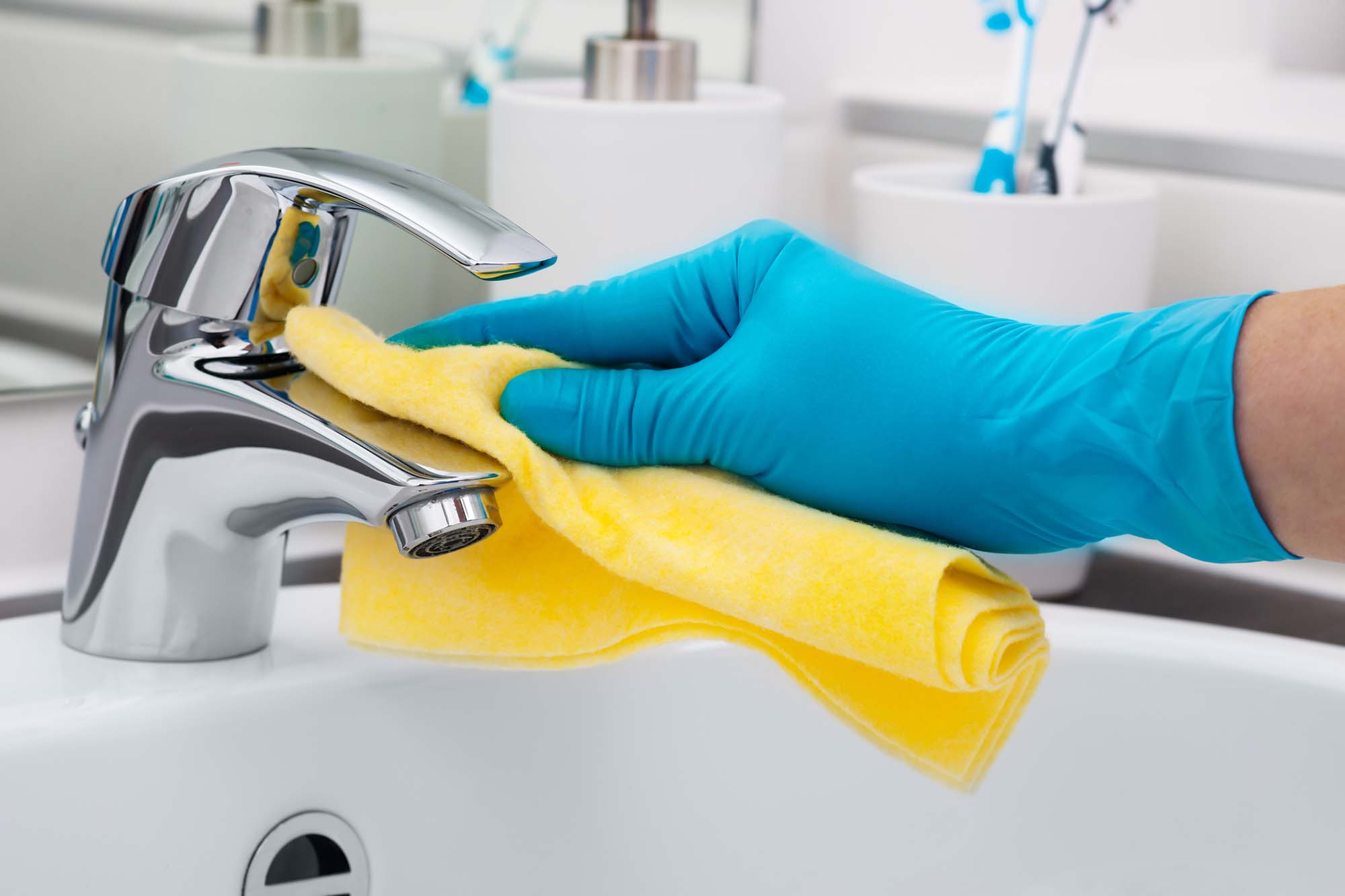 Woman doing chores in bathroom, cleaning tap